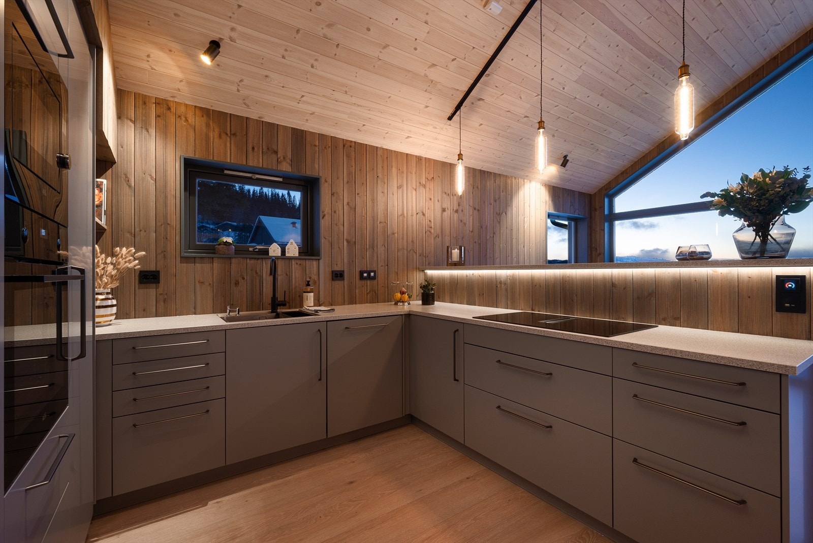 Ut mot stuen er det en halvvegg som gjør at man kan lage mat og samtidig få godt med lys og nydelig utsikt. Galleribilde