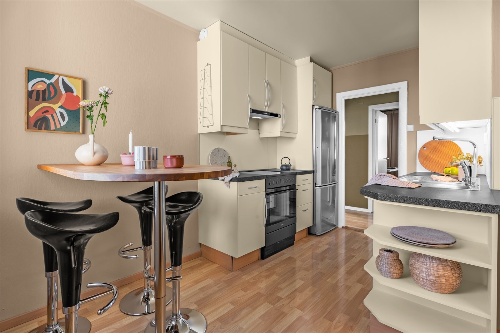 Kjøkkeninnredningen består av fronter med glatt utførelse, benkeplate i laminat og nedfelt kum i rustfritt stål. Galleribilde