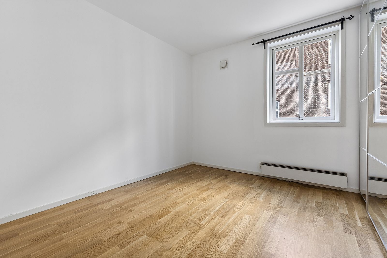 Rosmlig soverom med stor skyvedørsgarderobe med speil. Galleribilde