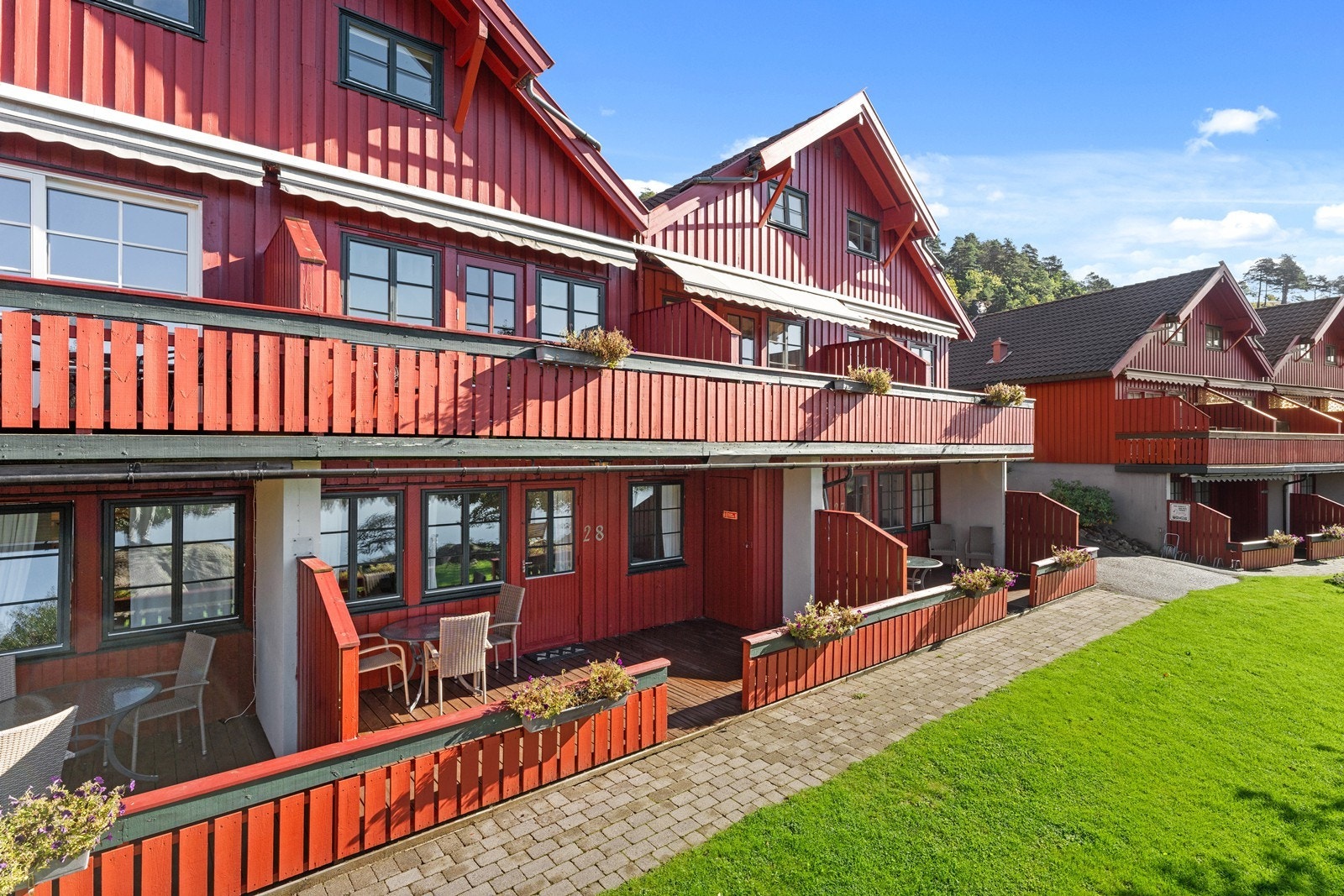 Solrik terrasse med god plass til sittegrupper og en egen utebod Galleribilde