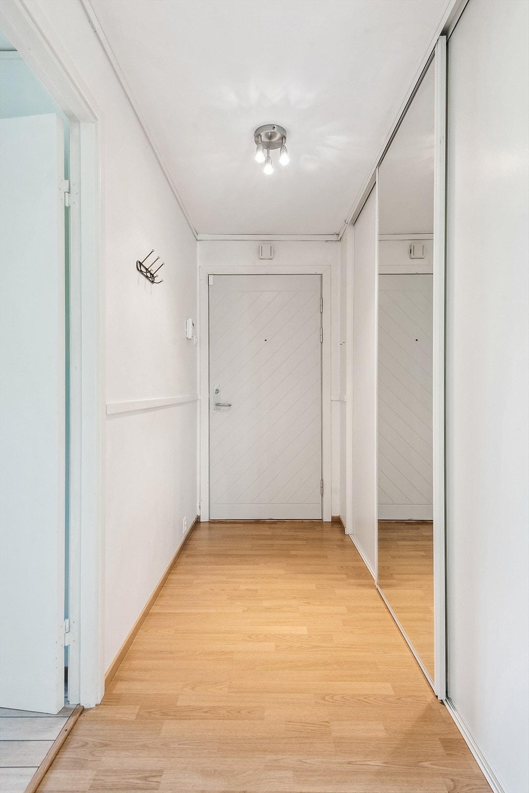 Entréen er lys og har en svært praktisk skyvedørsgarderobe med speildør. Galleribilde