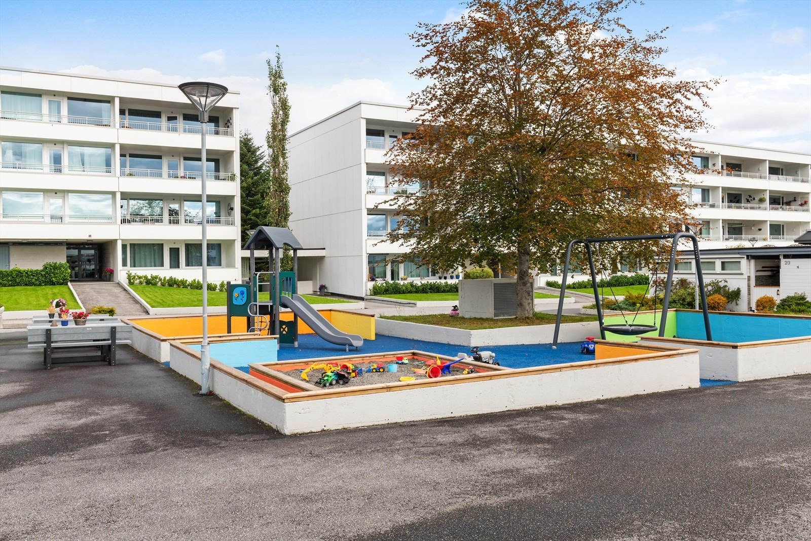 Tomten er pent opparbeidet med lekearealer, beplanting, plener etc. Galleribilde