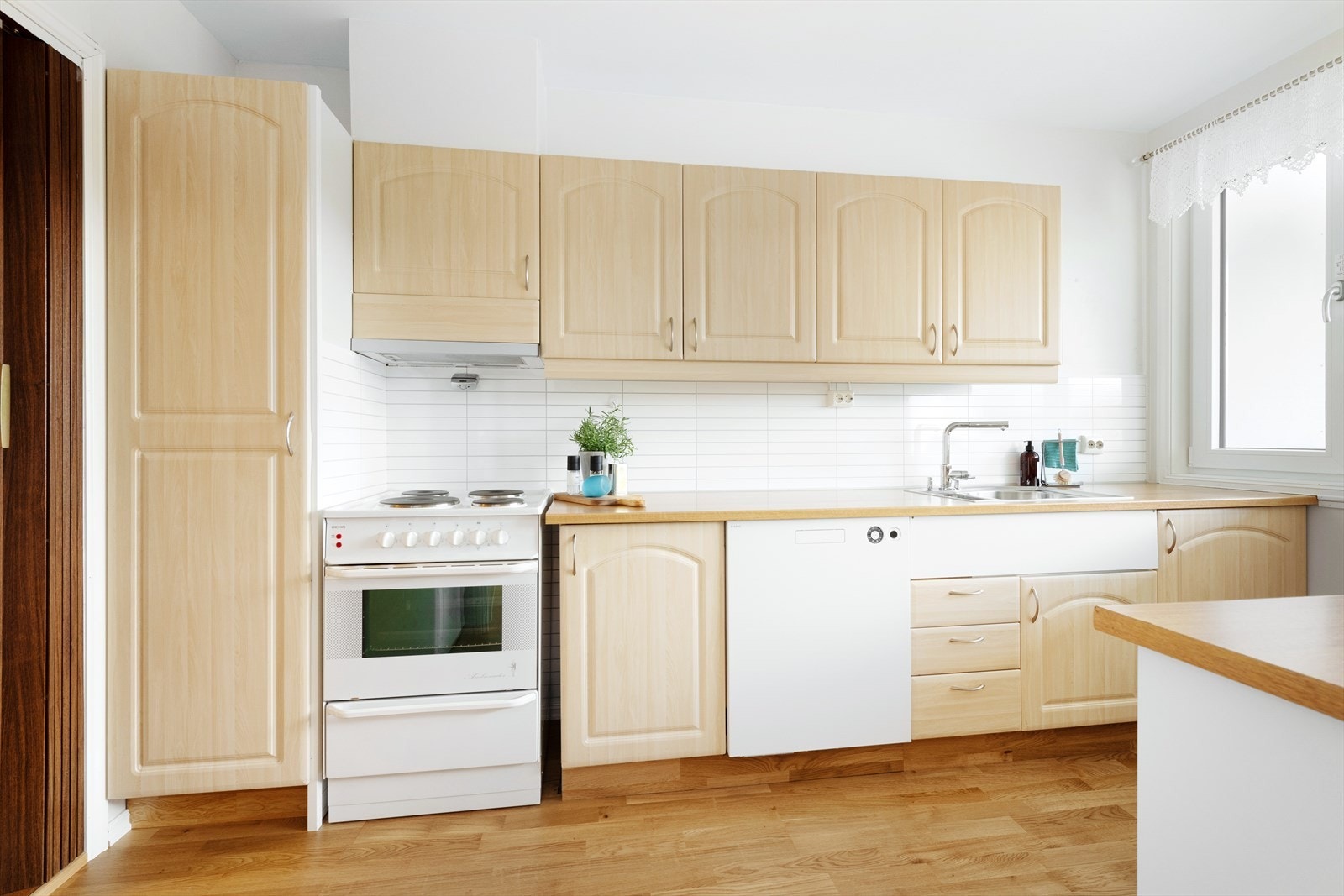 Kjøkkenet er innredet med lyse, profilerte fronter. Galleribilde