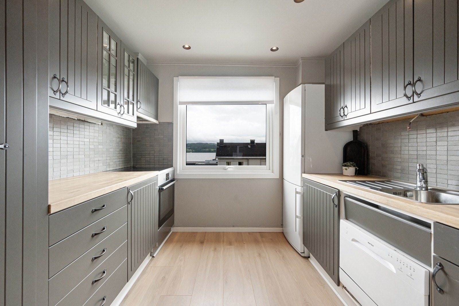 Kjøkkenet, som ligger i tilknytning til stuen, er utstyrt med malt innredning og profilerte fronter, og har plass til alle nødvendige hvitevarer. Galleribilde