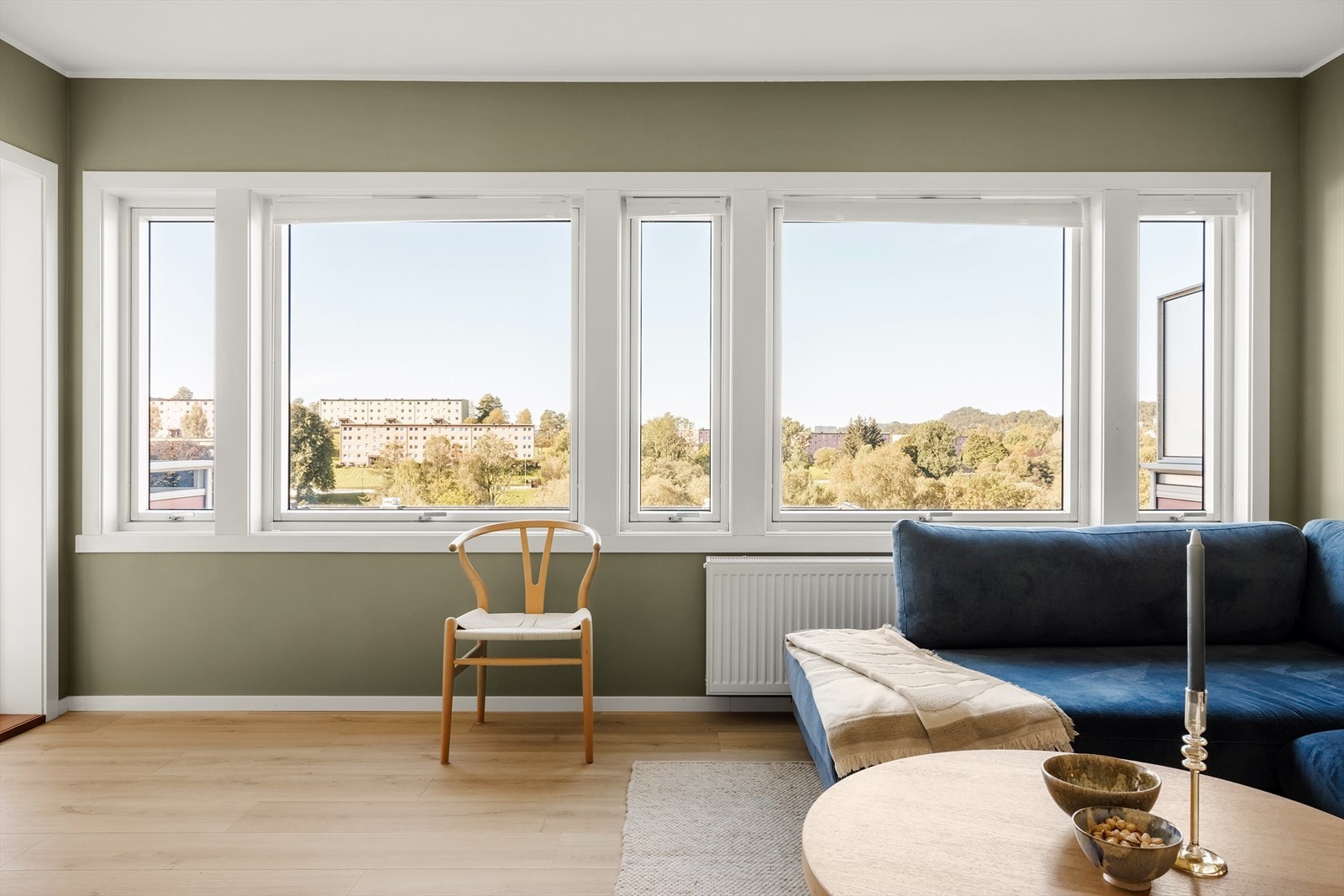 Vi beveger oss videre til hjertet av boligen, nemlig stuen. Her blir vi møtt av store vindusflater som sørger for rikelig av naturlig lysinnslipp. Galleribilde