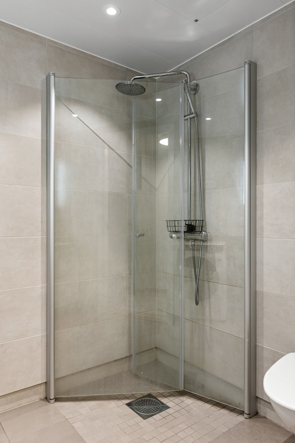 Badet er utstyrt med dusjhjørne med regnfallsdusj og innfellbare glassvegger Galleribilde