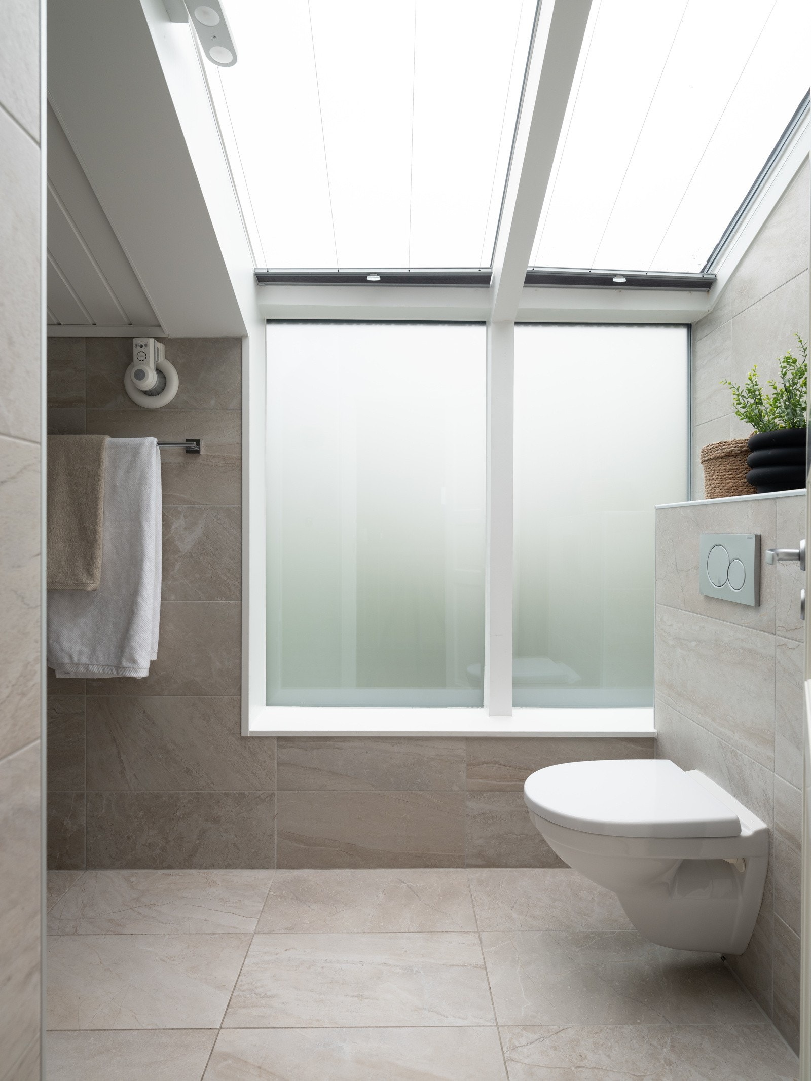 Flislagt bad i toppetasjen med frostede vindu for fin naturlig belysning. Galleribilde