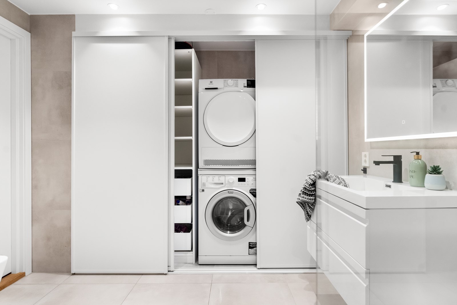 Bak skyvedører er det skapinnredning og opplegg for vaskemaskin. Galleribilde