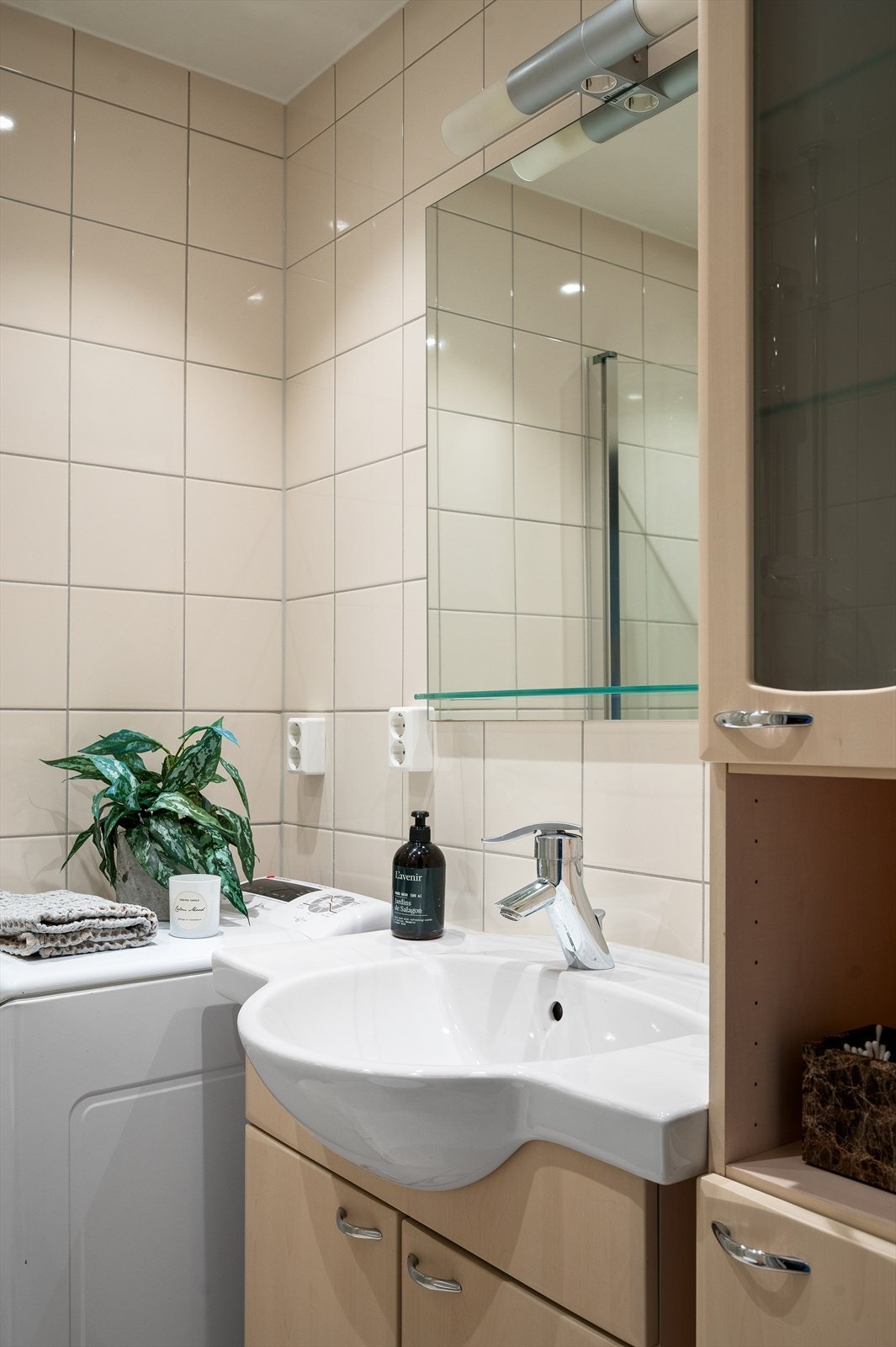 Badet er innredet med vegghengt toalett med innebygd sisterne kasse, servant på vegghengt servantskap, vegghengte dusjdører i glass. Galleribilde