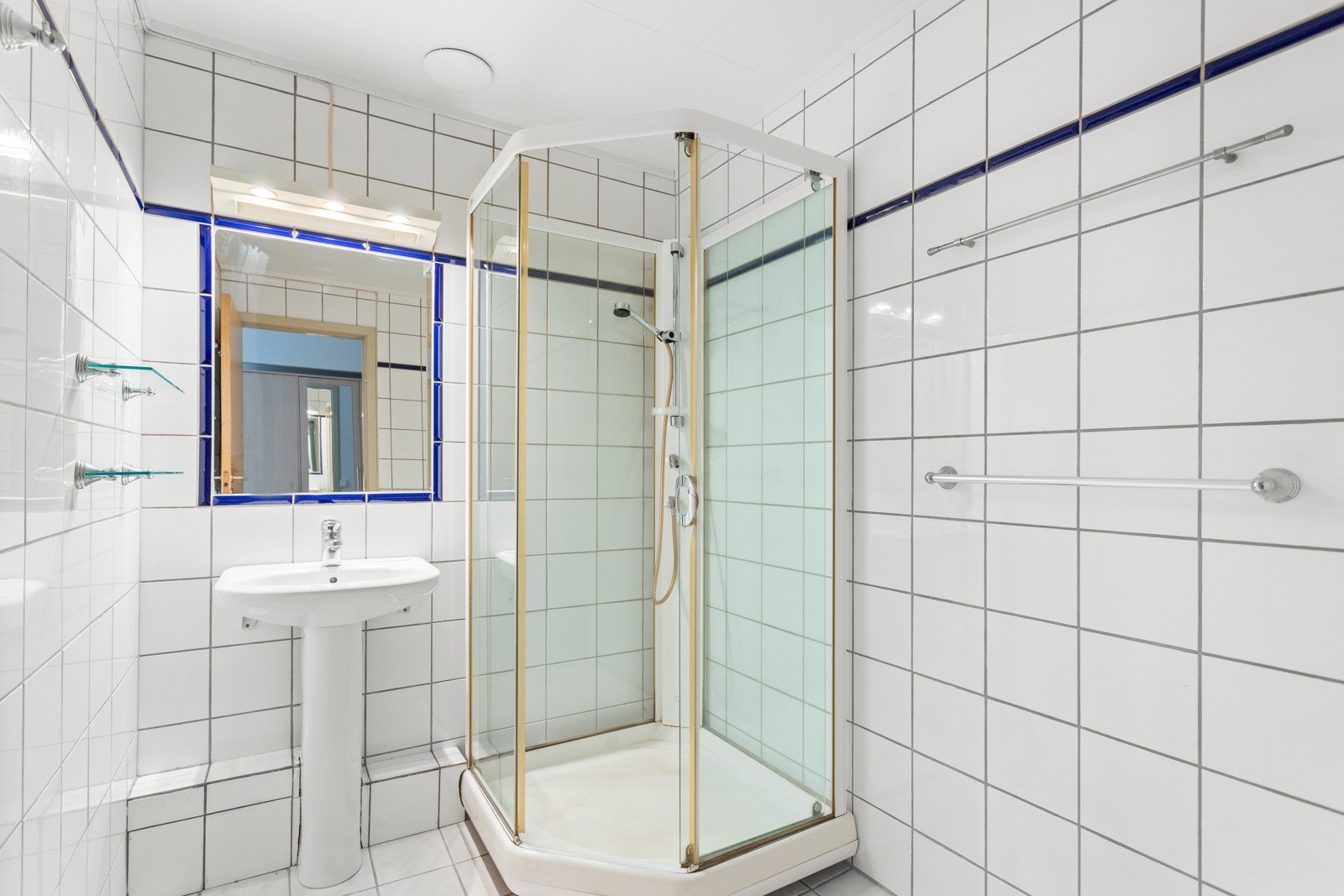 Bad med dusjkabinett, vask og vegghengt speil. Galleribilde