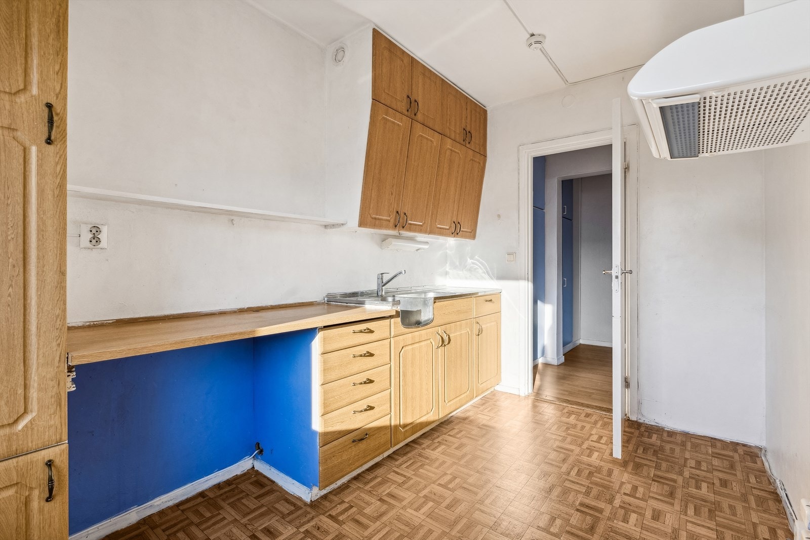 Eldre kjøkkeninnredning med profilerte fronter. Kjøkkenventilator med kullfilter. Galleribilde