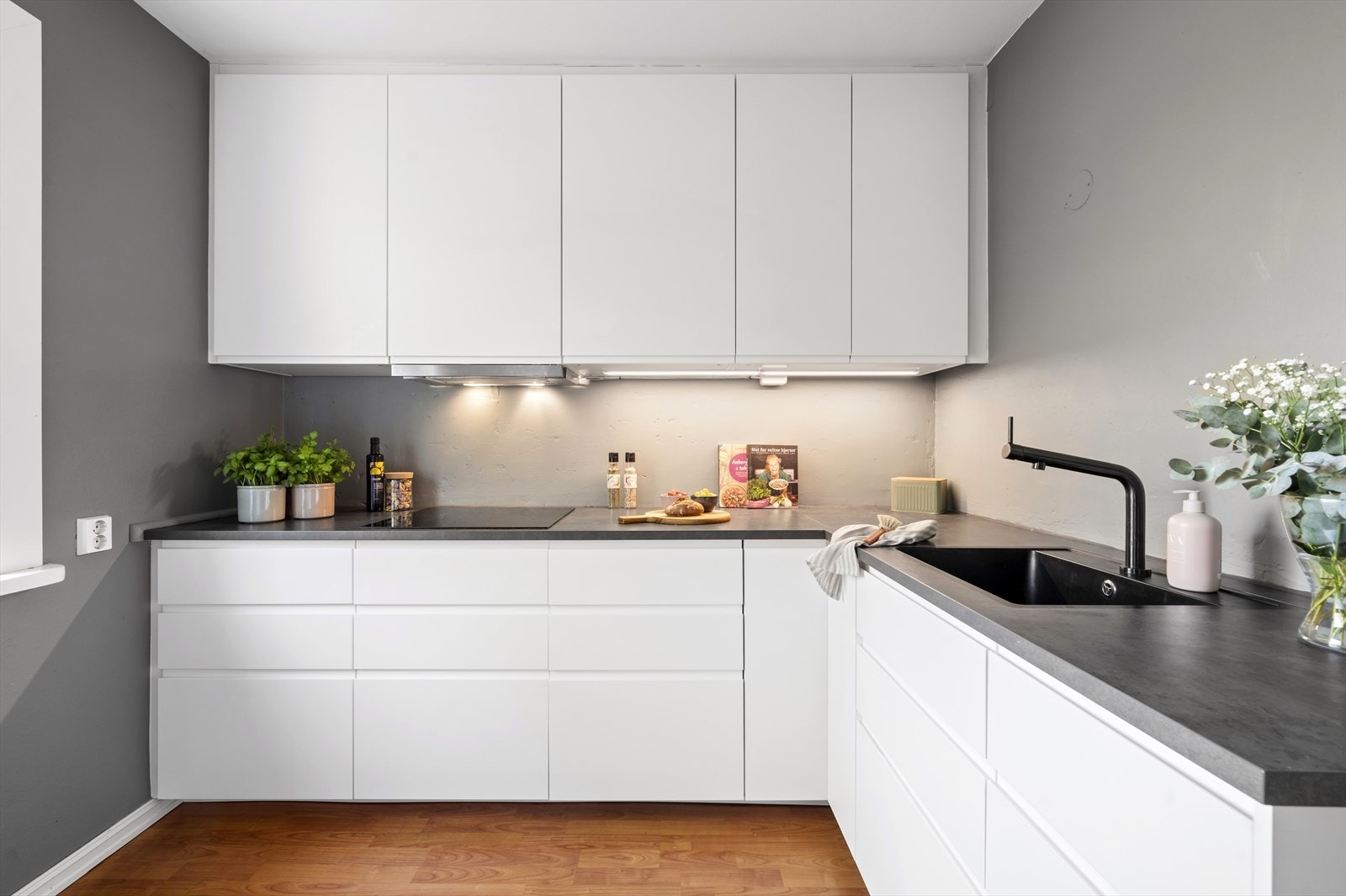 Kjøkkeninredningen er tidløs og moderne med glatte fronter, laminert benkeplate med integrert kjøkkenkum. Galleribilde