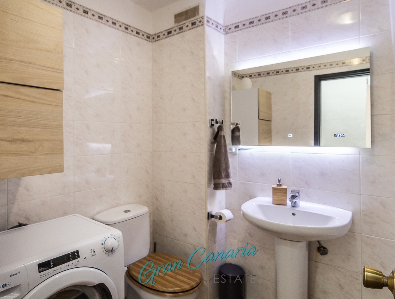 Bad med vask, toalett, badekar med dusjgarnityr og vaskemaskin Galleribilde