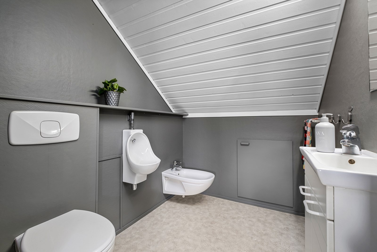 Badet er utstyrt med servant med vask, underskap, bidet, urinal og toalett med innebygd sisterne. Det er også kneloft på sidene for ekstra lagringsplass Galleribilde