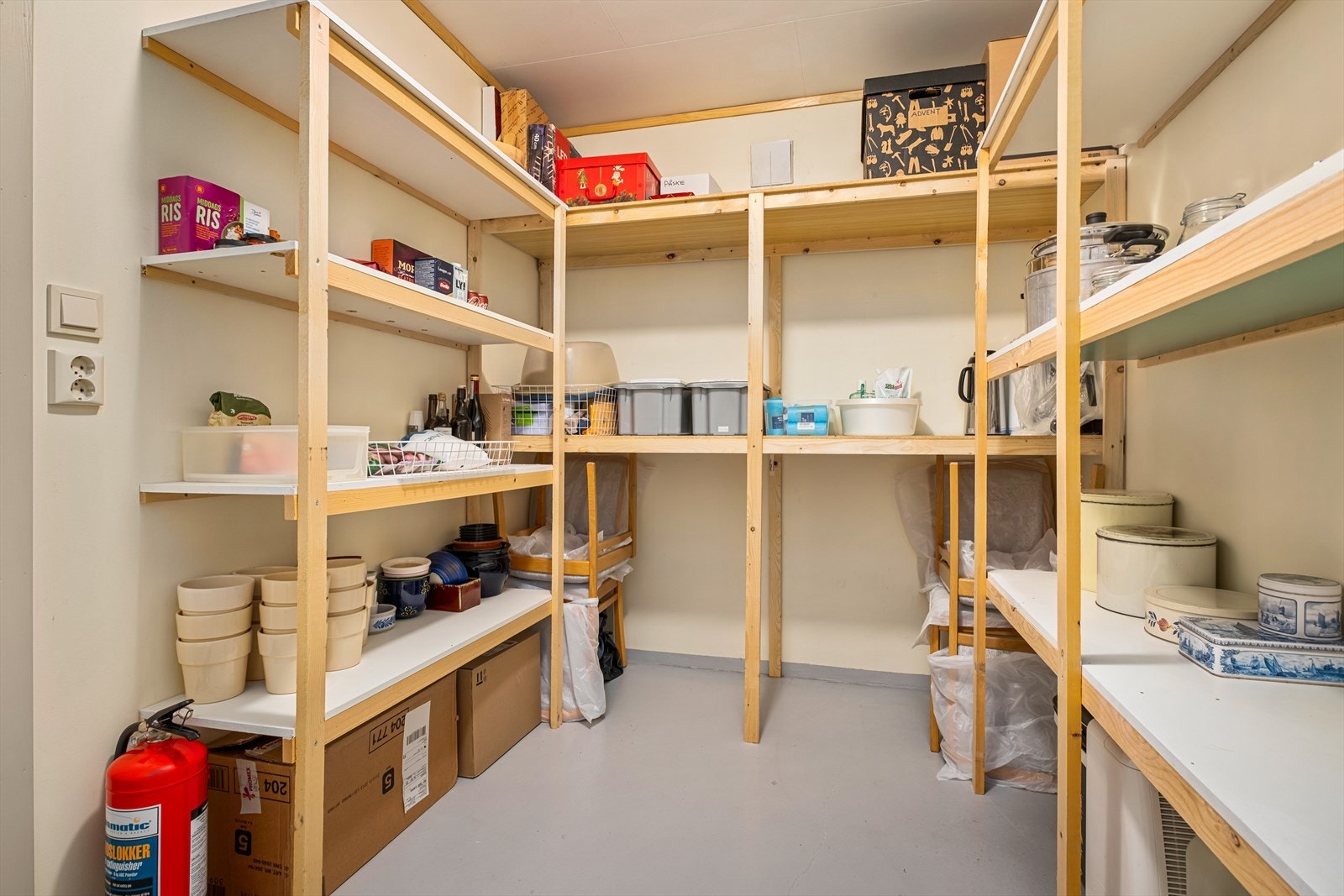 Romslig bod på 7,5 kvm innredet med praktisk hyllesystem. Stikkontakt for eventuell fryser. Galleribilde