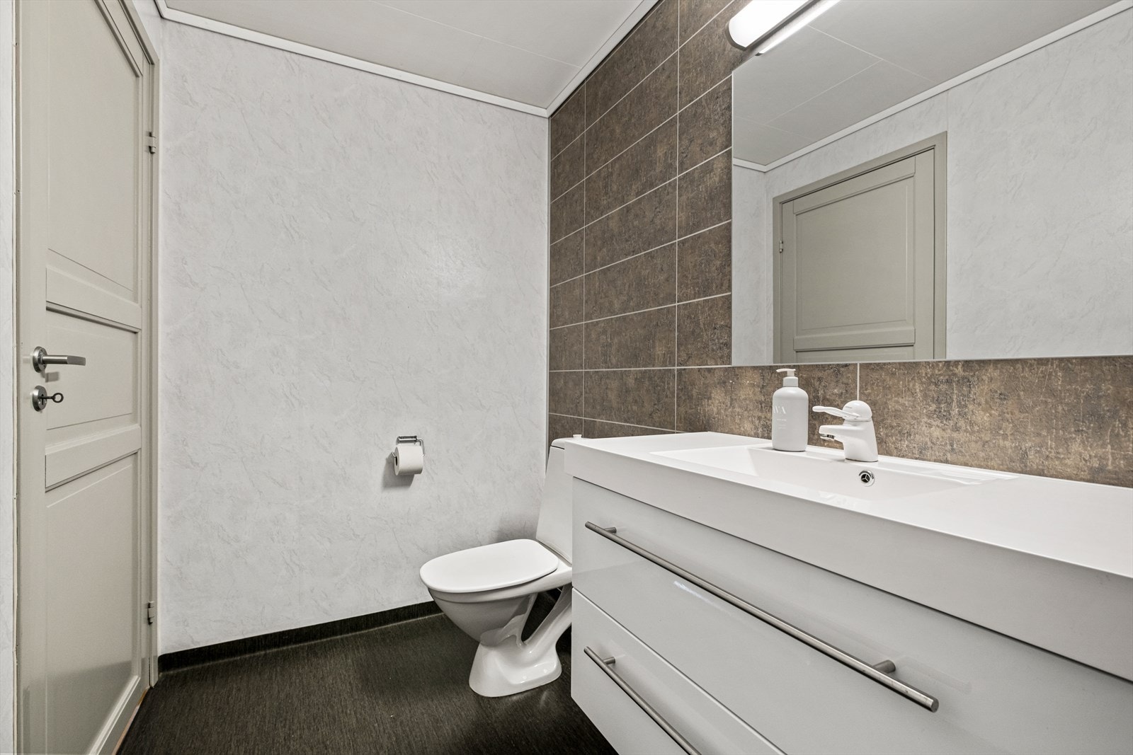 Badet har slitesterke materialer som våtromsplater og vinyltapet på vegg samt våtromsbelegg på gulv. Galleribilde