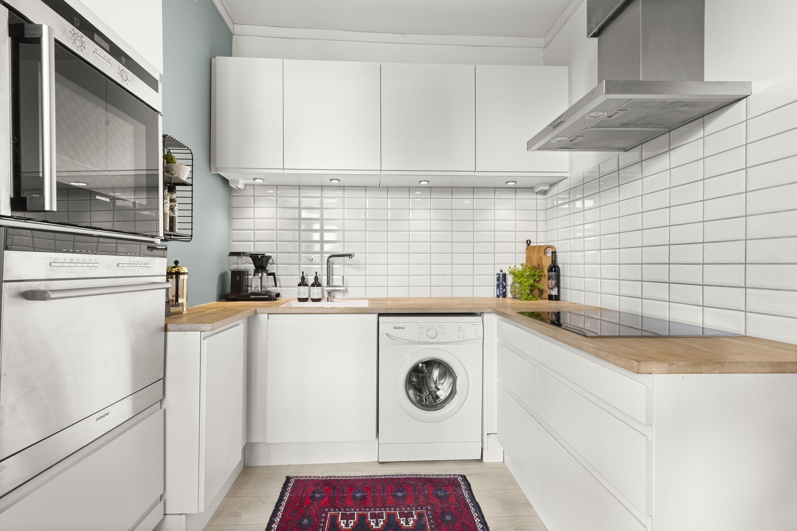 Det er lagt fliser over benkeskap og montert belysning under overskap. Galleribilde