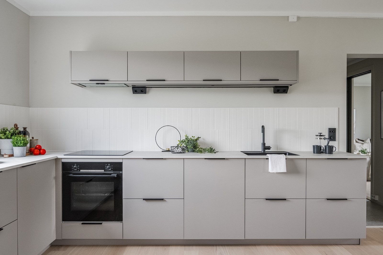 Innredningen har glatte fronter og laminert benkeplate med nedfelt sort oppvaskkum og sort armatur. Galleribilde