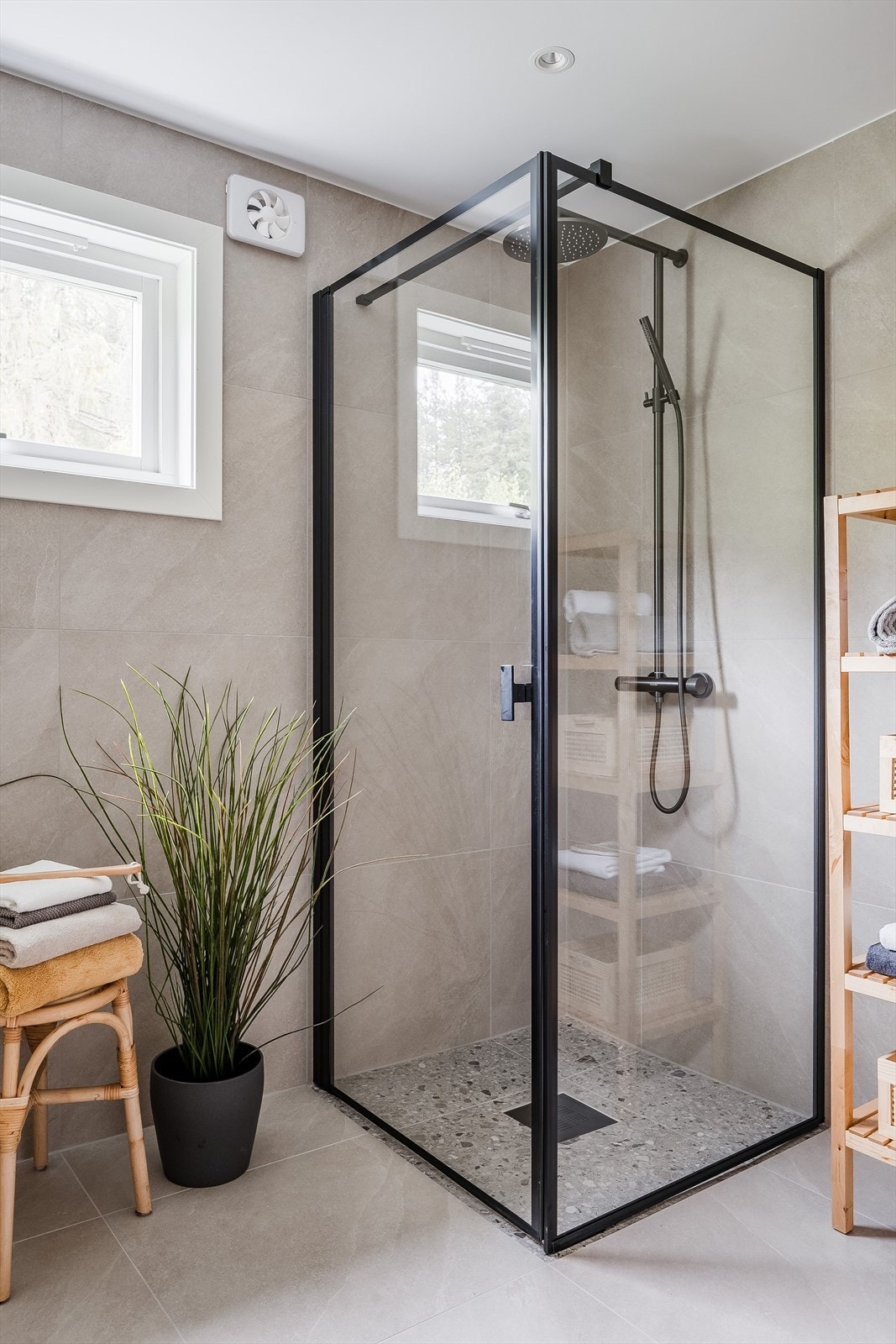 Baderommet er også utstyrt med dusjhjørne med glassdører og sort armatur med både hånd- og regnfallsdusj, samt vegghengt toalett. Galleribilde