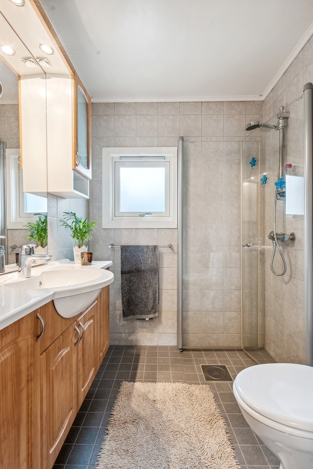 Badet har fliser på gulv og vegger. Det er elektriske varmekabler Galleribilde