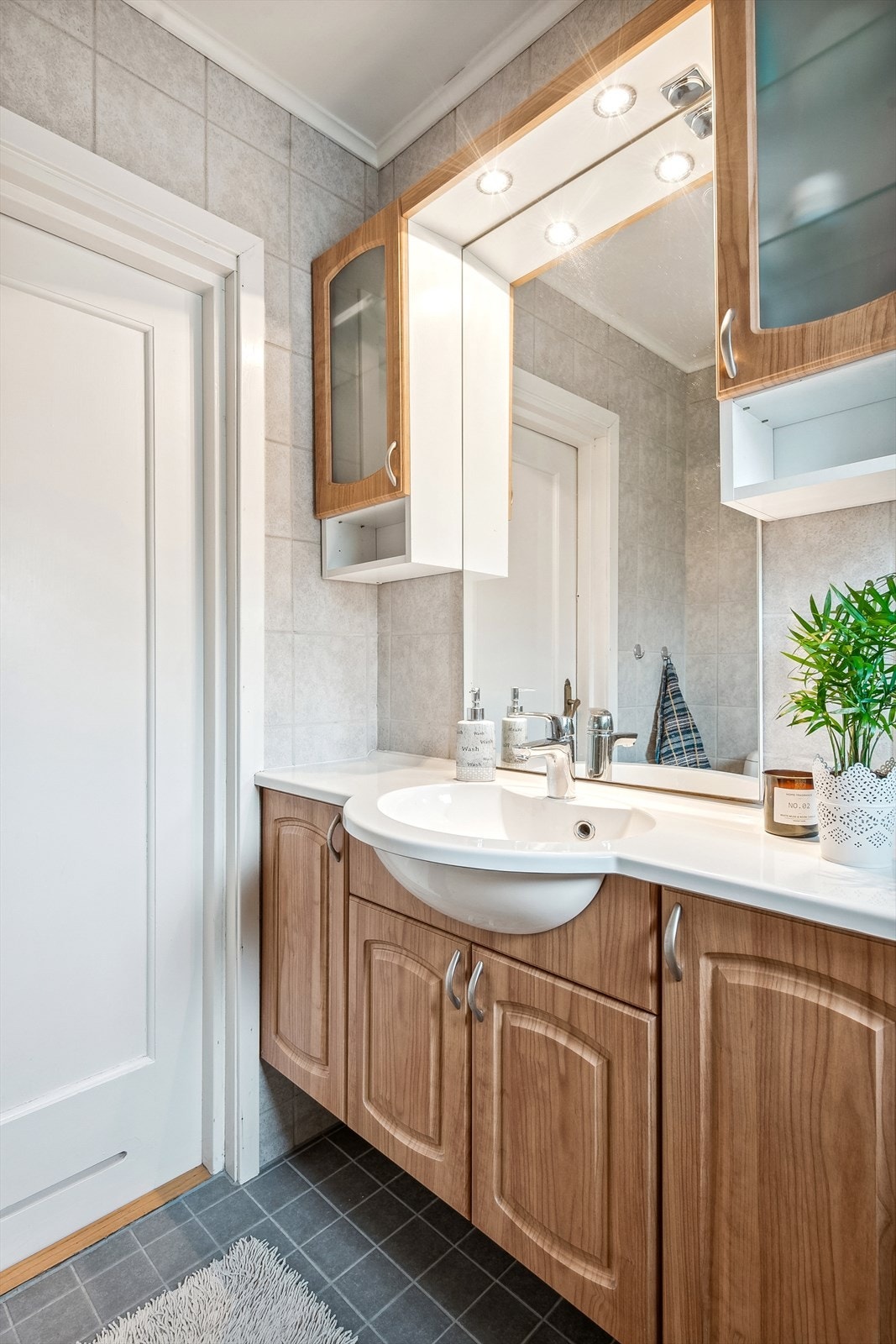 Badet har innredning med heldekkende servant, gulvmontert toalett, og dusjhjørne med glassvegger Galleribilde