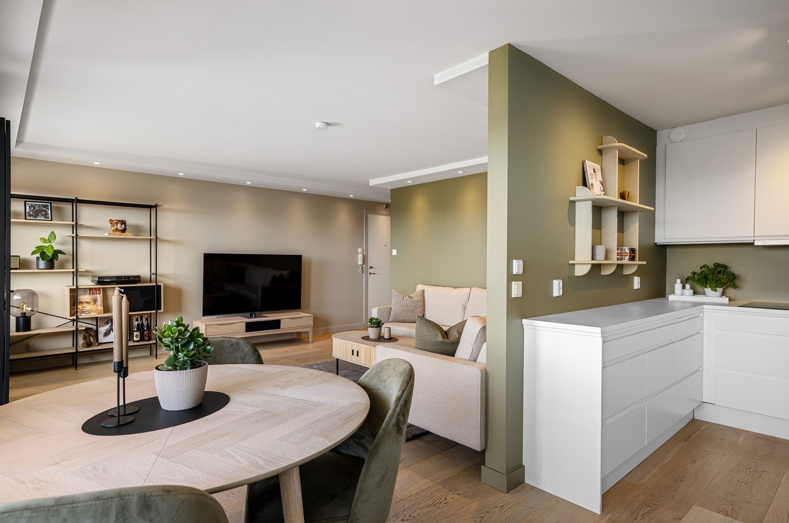 Kjøkkeninnredningen har hvite glatte fronter med laminert benkeplate og nedfelt oppvaskkum med 1-greps blandebatteri. Galleribilde