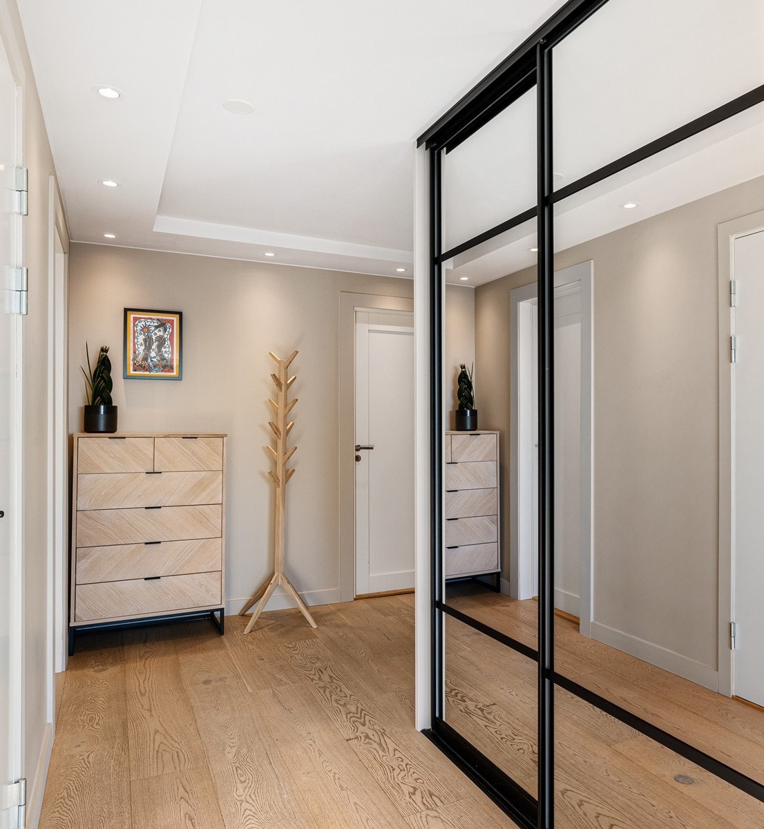 I entreen er det to skyvedørsgarderober med speilfronter, hvor det er god plass til oppbevaring av klær og sko. Galleribilde