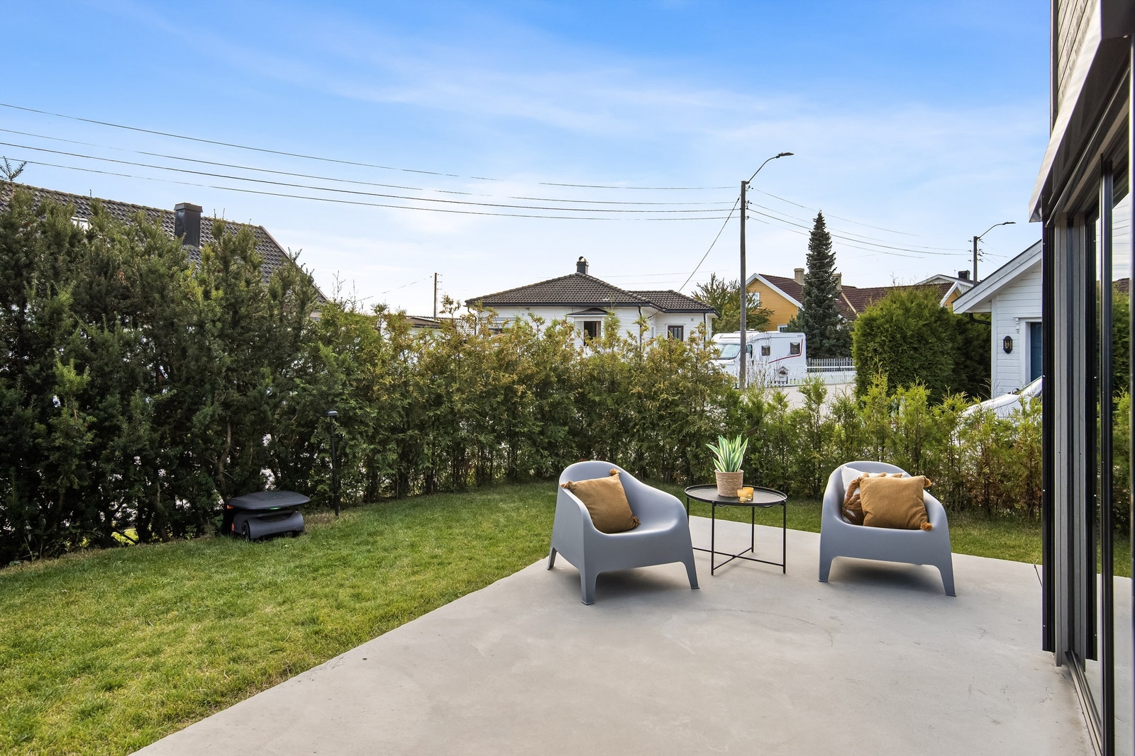 Koselig støpt uteplass, godt skjermet med tujahekk Galleribilde