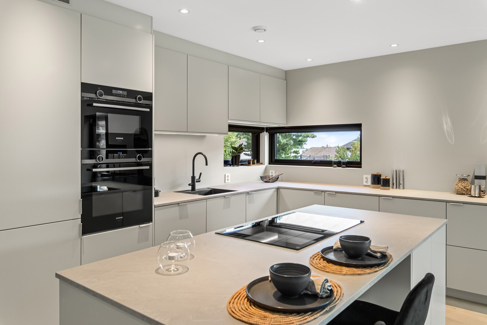 Lys grå laminat benkeplate med induksjonstopp med integrert vifte. Galleribilde