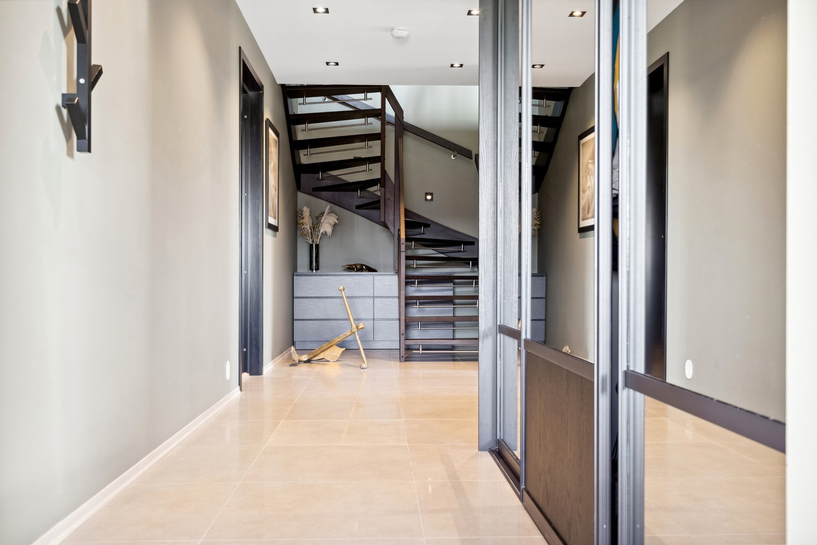 Hoveddel: Gangen er innredet med skyvedørsgarderobe, fliser på gulv og downlights i himling. Galleribilde