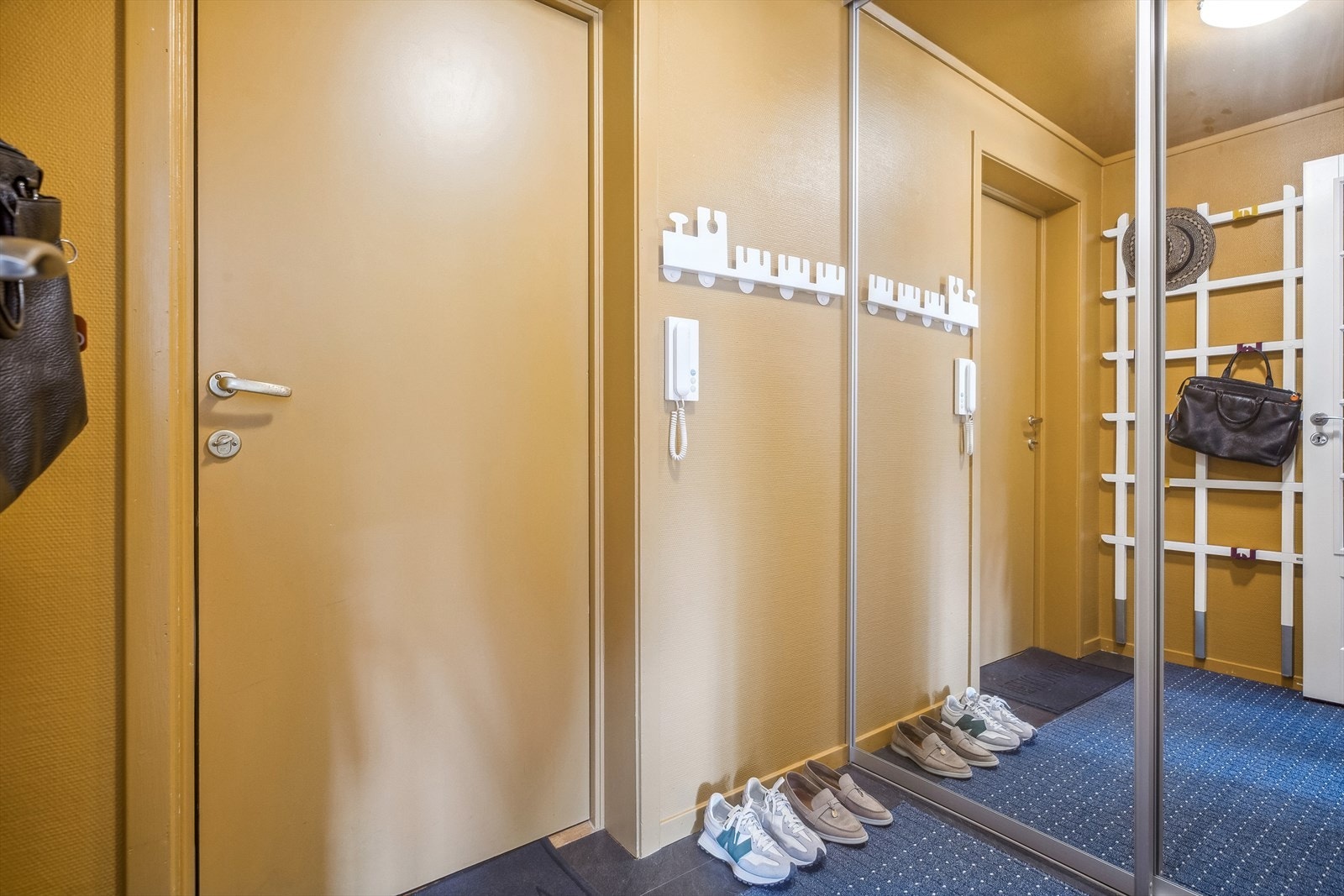 Leiligheten har inngang til en pen entré med både vegger og inngangsdør malt i en varm farge. Galleribilde