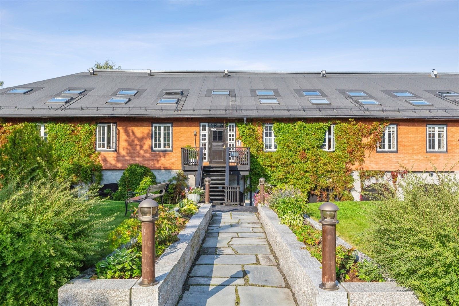 Frem til inngangspartiet er det en gangsti med skiferstein og fine bed på hver side. Galleribilde