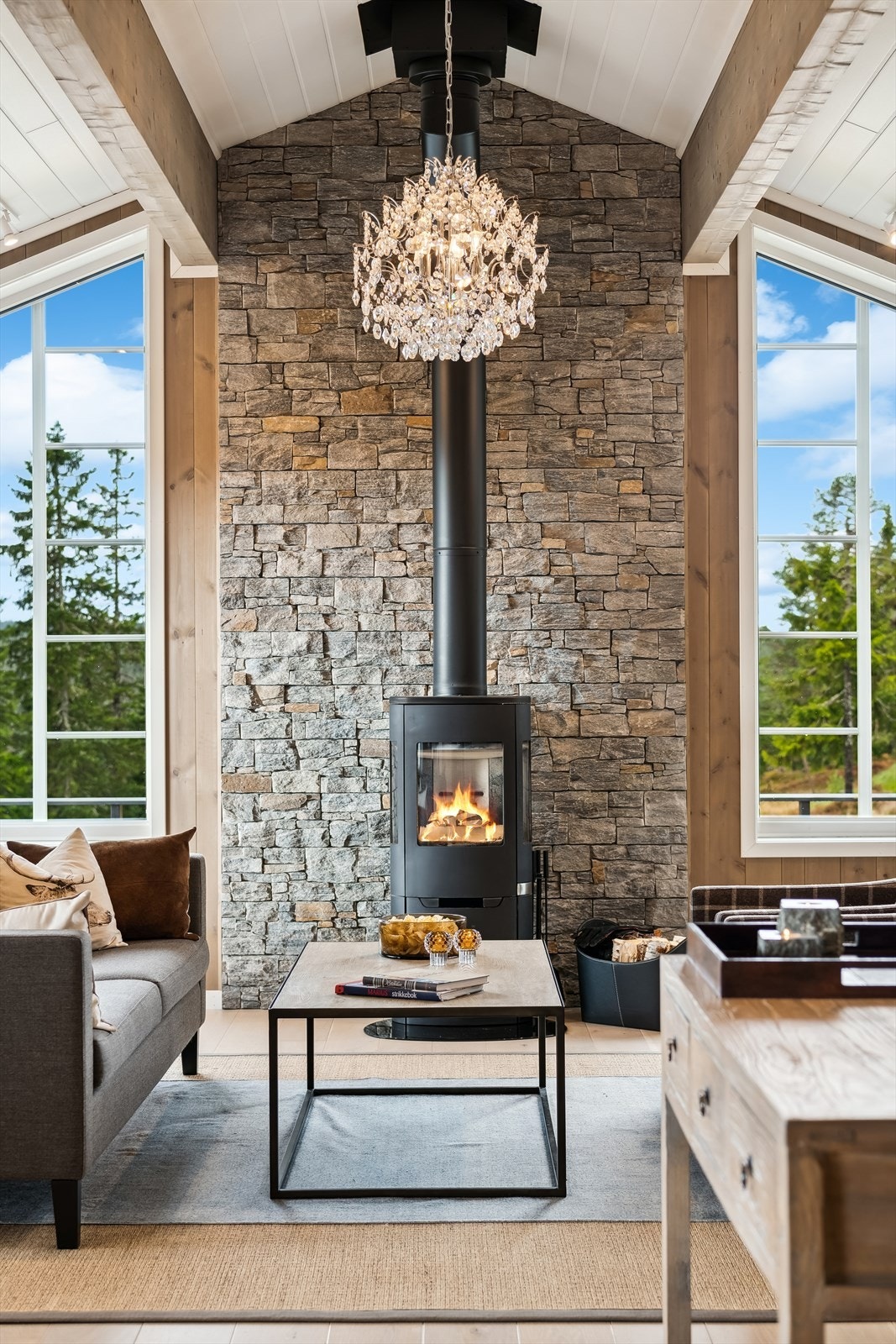 Peisovnen og den flotte steinveggen er et flott blikkfang og varmen fra peisovnen skaper en hyggelig atmosfære i rommet Galleribilde