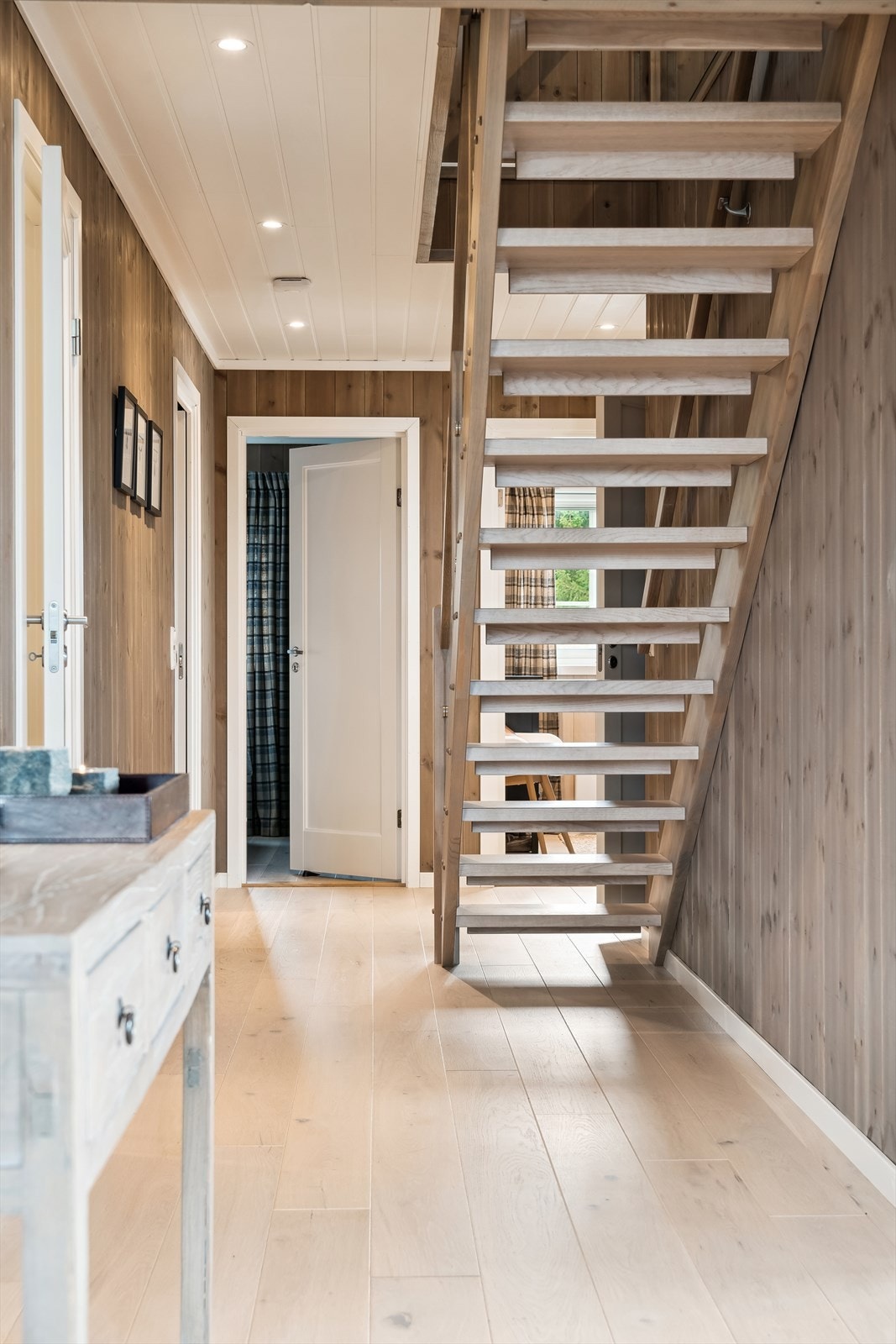 Trappen mellom etasjene ligger i gangen. Heltre trinn og glasset rekkverk. Galleribilde