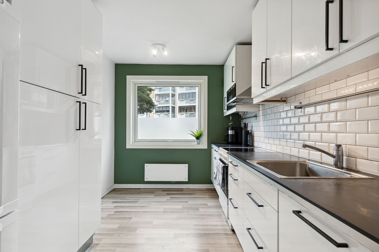 Separat kjøkken med moderne slette fronter og hvitevarer. Galleribilde