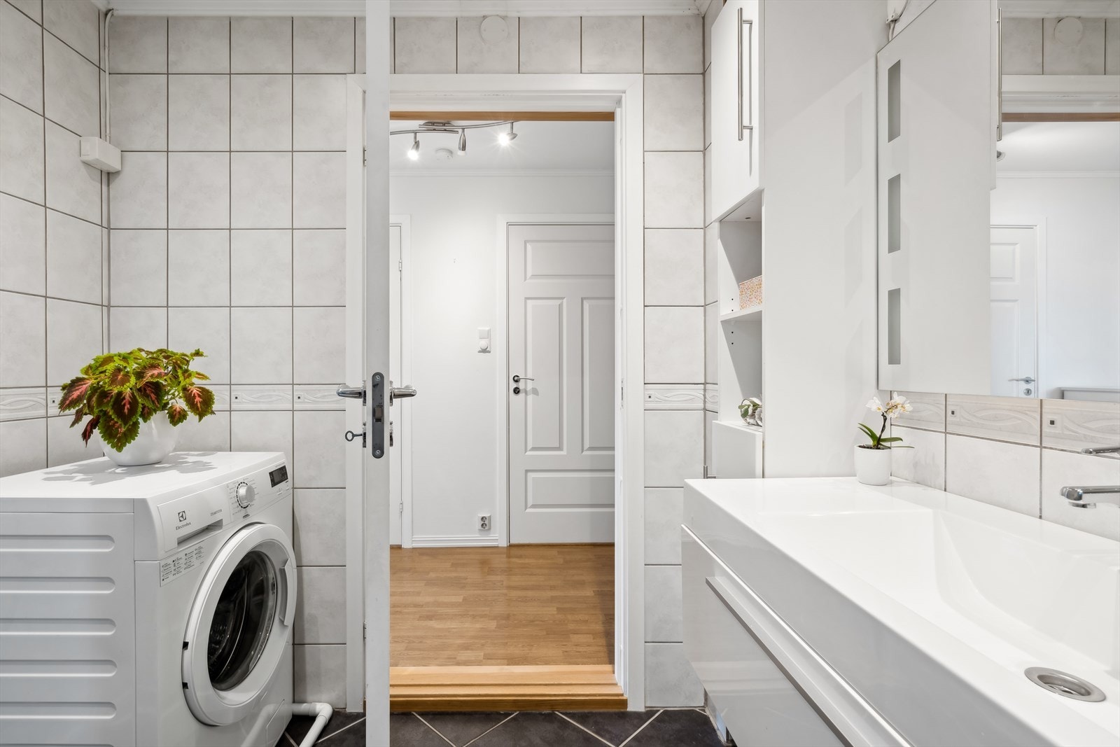 Badet er innredet med servantskap med ett-greps blandebatteri, speil med lys, høyskap og dusjkabinett. Det er opplegg for vaskemaskin. Galleribilde
