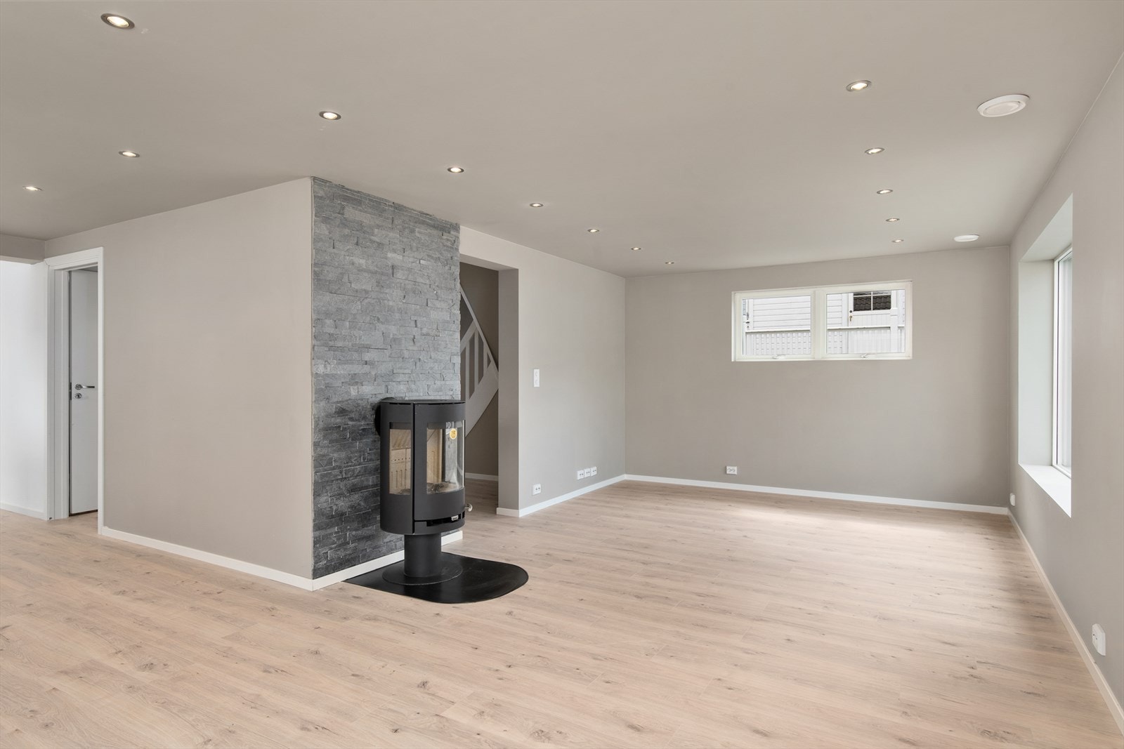 Romslig stue med vedovn som varmekilde. Galleribilde