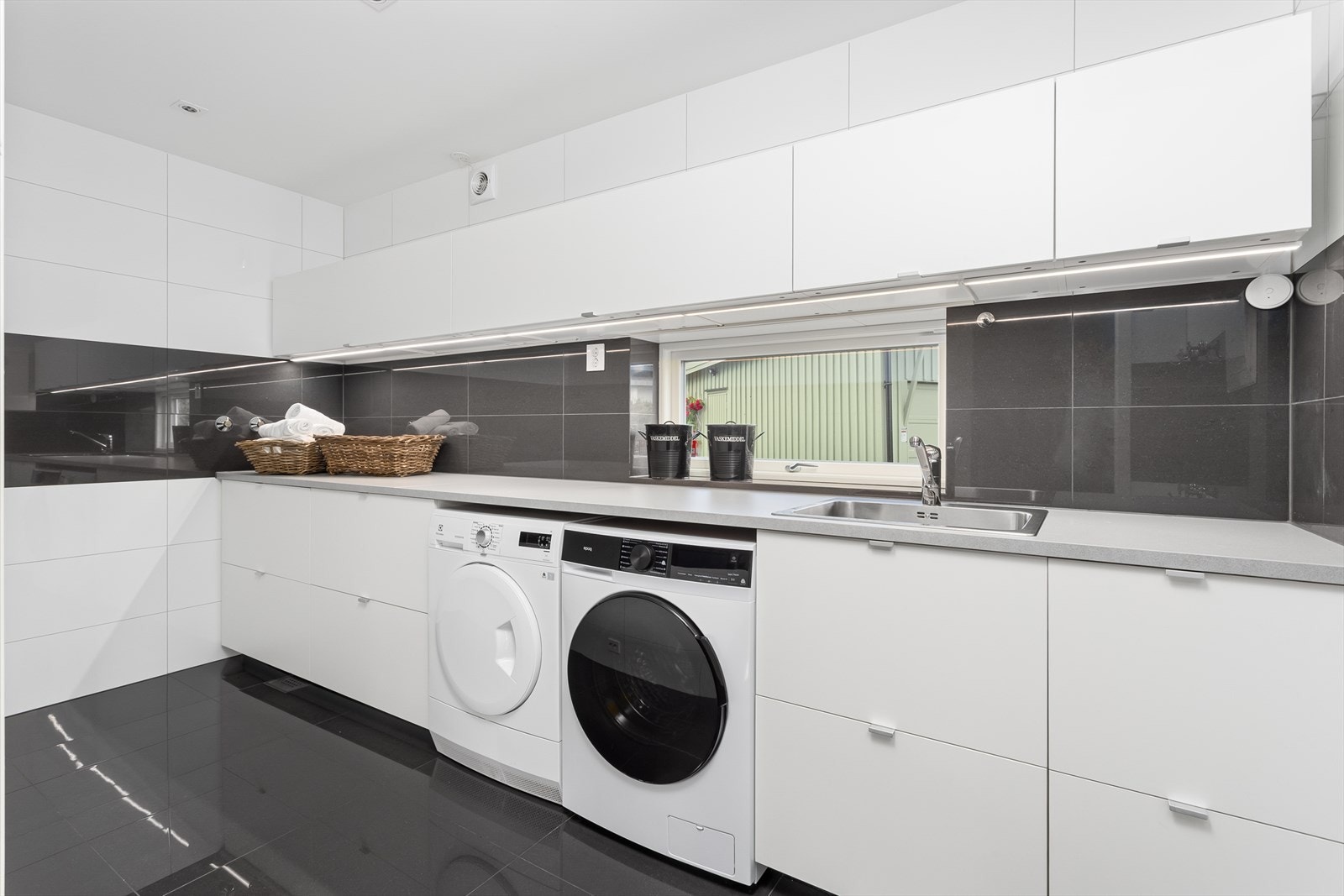 Moderne og praktisk vaskerom godkjent som våtrom. Opplegg for vaskemaskin/tørketrommel, samt dusj. Varmekabler i gulv. Ledskinne under skap. Galleribilde