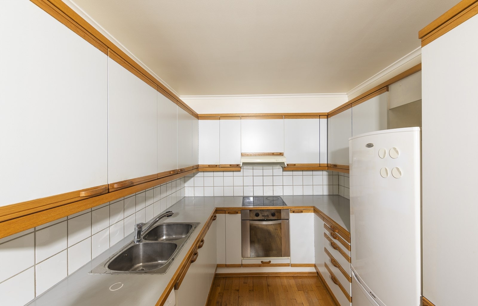 Kjøkkeninnredningen er fra byggeåret og har slette fronter med heltre benkeplate. Den inkluderer frittstående hvitevarer samt integrert oppvaskkum, komfyr og platetopp. Galleribilde