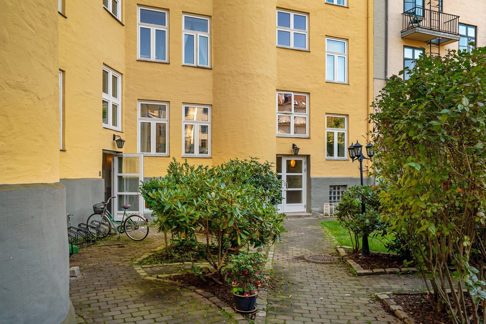 Sykkelstativ og beplantning i bakgården. Galleribilde