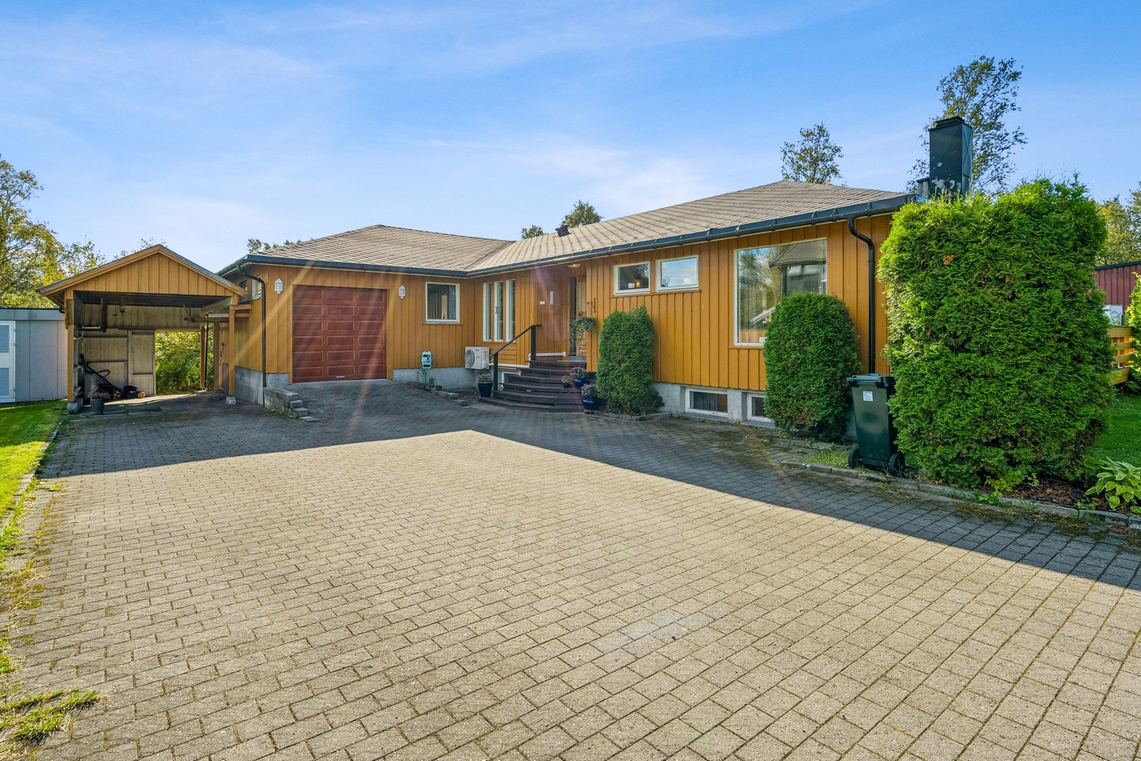 Det er godt med parkeringsplasser på brosteinsbelagt innkjørsel, garasje og carport. Galleribilde