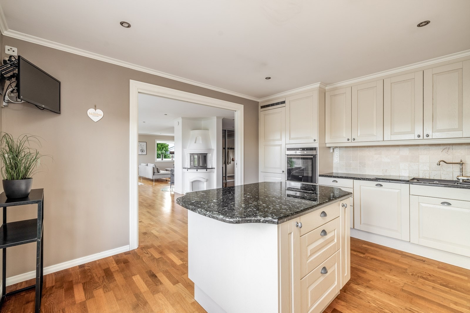 Kjøkkenet ligger i delvis åpen løsning mot stuen, med de samme, fine overflatene og downlight belysning med dimmer i tak. Mellom stuen og kjøkkenet er det plassbesparende skyvedør om man ønsker å lukke mellom rommene. Galleribilde