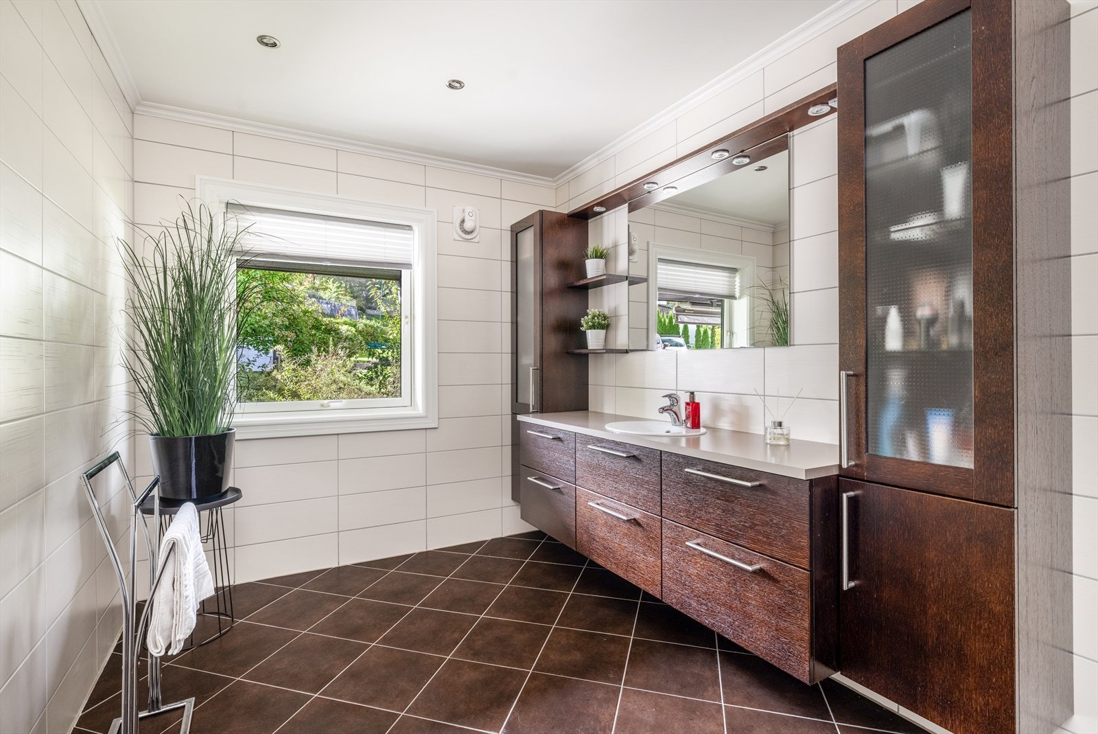 Badet fra 2011 har fliser på gulv med varmekabler og baderomspanel på veggoverflater. Galleribilde