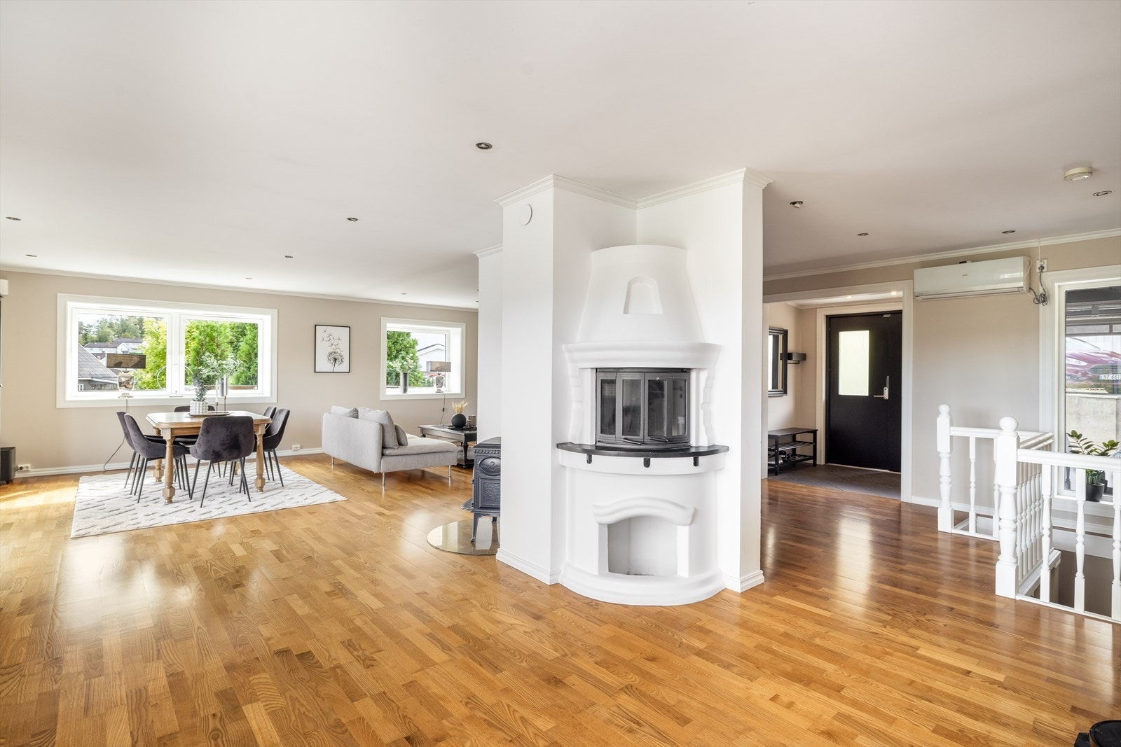 Stuen har gode soner for møblering, og her er installert både vedovn med glassplate under og en koselig peis med pyntehyller og peisinnsats. Galleribilde