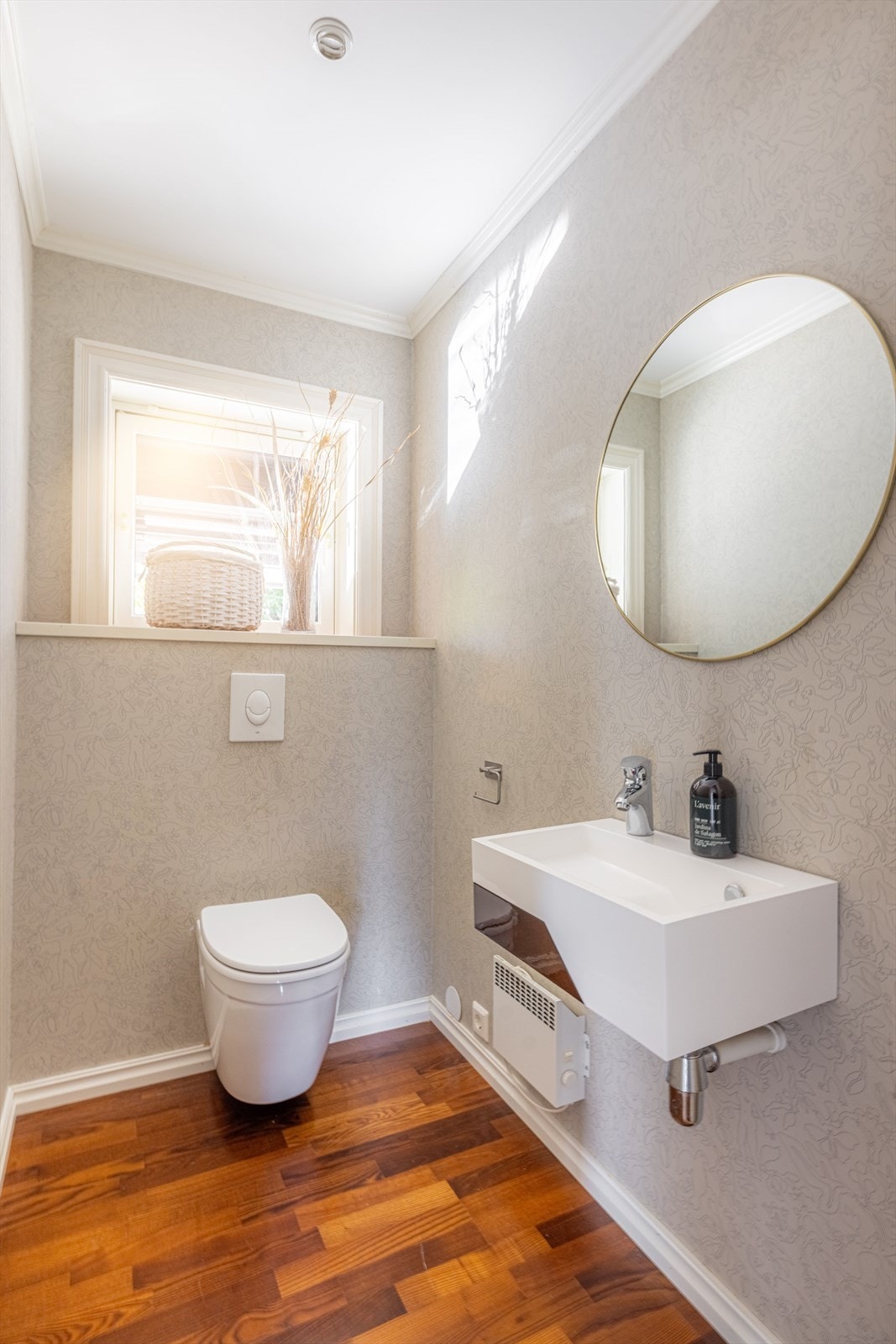 Boligen har også et pent gjestetoalett inntil gangen, med vaskeservant og vegghengt toalett. Her er det tapet på vegger og parkett på gulv. Galleribilde
