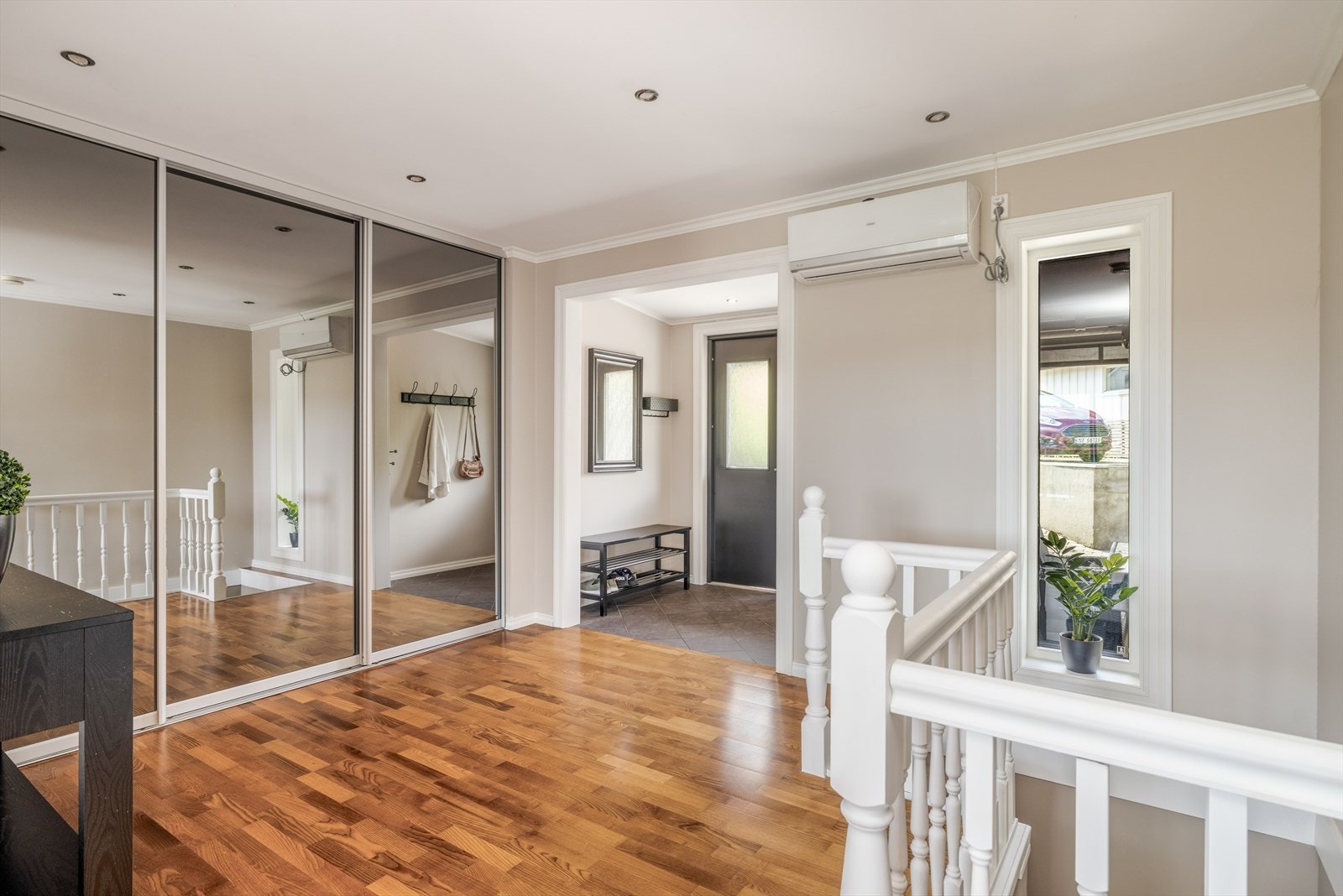 Videre inn er det en romslig gang med parkett på gulvet som går videre inn i boligen og gir en fin helhet. I gangen er det godt med oppbevaringsplass i skyvedørsgarderobe med speildører. Galleribilde