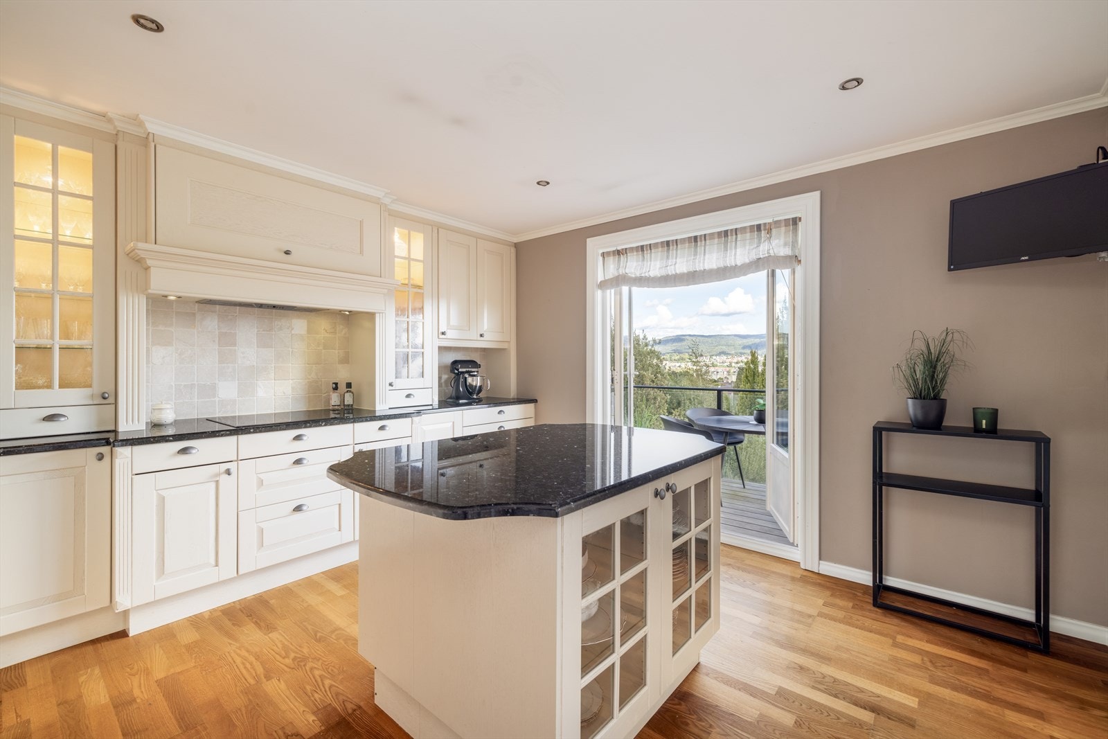 Fra kjøkkenet er det tofløyet verandadør ut til terrassen hvor man kan nyte morgenkaffen og den nydelige utsikten. Galleribilde