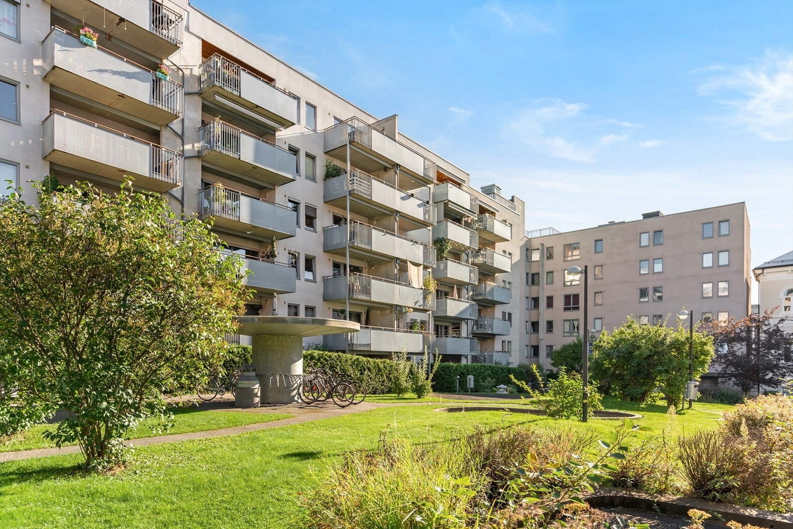 Bakgården er som en grønn oase - Her er det rikelig med beplantning i tillegg til sykkelparkering Galleribilde