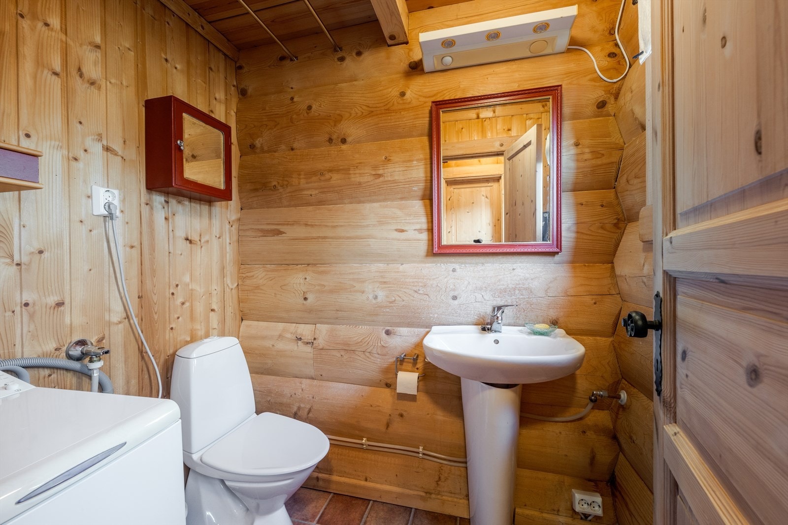 Badet er innredet med toalett, dusjkabinett og servant på vegg. Det er opplegg for vaskemaskin. Galleribilde