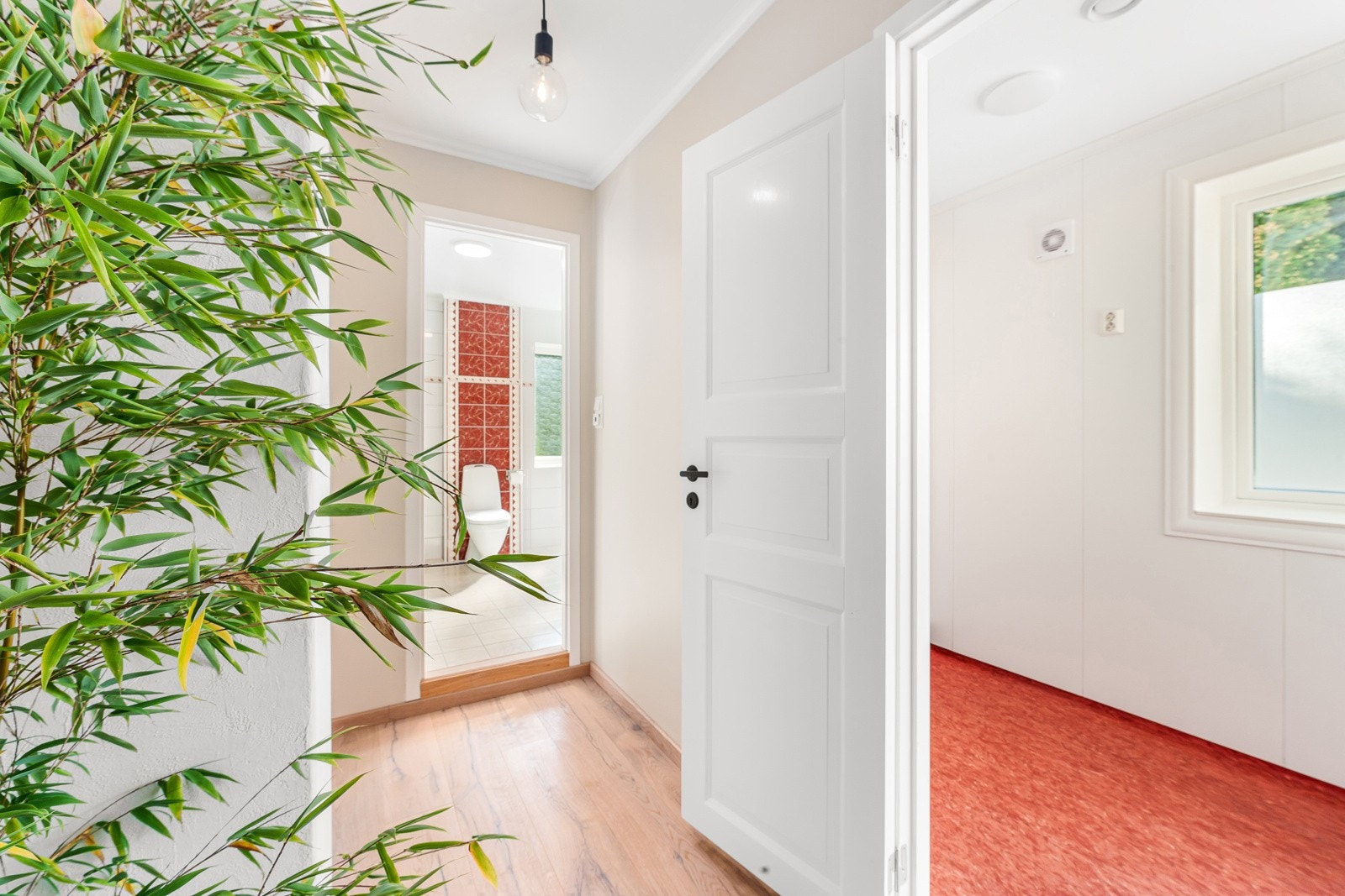 I enden av gangen er det inngang til et separat vaskerom og til badet. Meget praktisk med eget vaskerom. Galleribilde